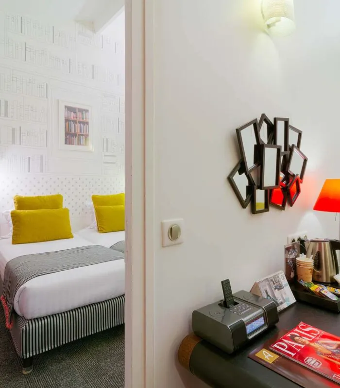 Appartement à l’hôtel Joyce avec un lit et un bureau sur lequel se trouve un magazine Paris