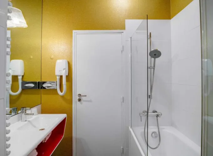 Appartement salle de bain à l’hôtel Joyce avec un mur jaune et une porte blanche
