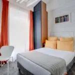 Chambre Communicante petite chambre d’hôtel avec un lit et un bureau à l’hôtel Joyce