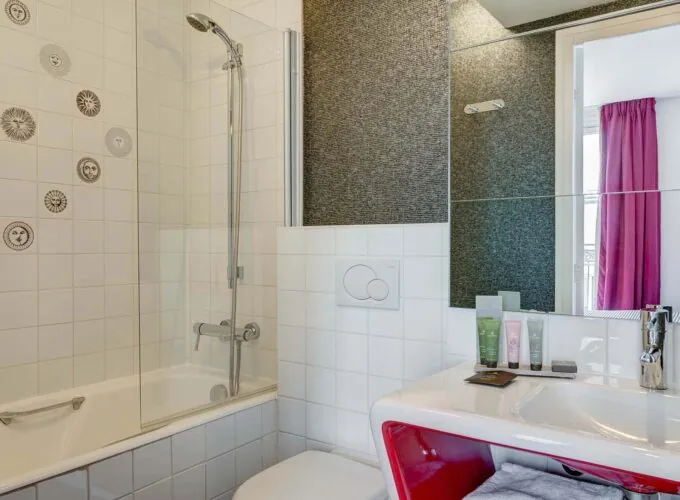 Salle de bain de la Chambre Communicante à l’hôtel Joyce avec une baignoire, un lavabo et un miroir