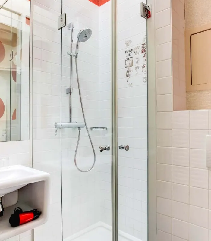 Salle de bain de la Chambre Communicante à l’hôtel Joyce avec des cercles rouges sur le mur et un lavabo