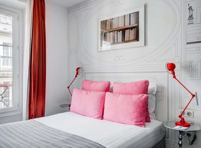 Chambre Double à l’hôtel Joyce avec un lit, des oreillers roses et une image accrochée au mur au-dessus