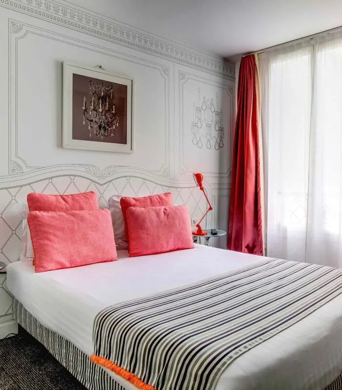 Chambre Familiale à l’hôtel Joyce avec des oreillers roses et des rideaux rouges