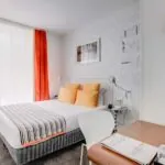 Chambre Familiale à l’hôtel Joyce avec un lit et un bureau avec un livre