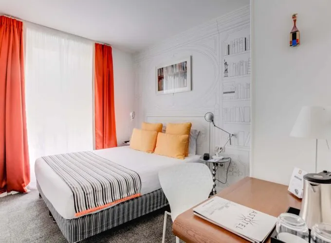 Chambre Familiale à l’hôtel Joyce avec un lit et un bureau avec un livre