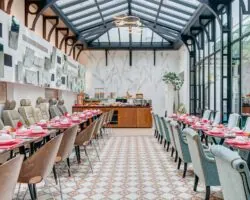 Salle de petit-déjeuner de l’hôtel Joyce 3 étoiles du groupe Astotel à Paris, située sous une verrière avec une décoration originale et un buffet à l’arrière