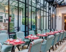 Salle de petit-déjeuner de l’hôtel Joyce 3 étoiles du groupe Astotel à Paris, située sous une verrière avec une décoration originale et un buffet à l’arrière
