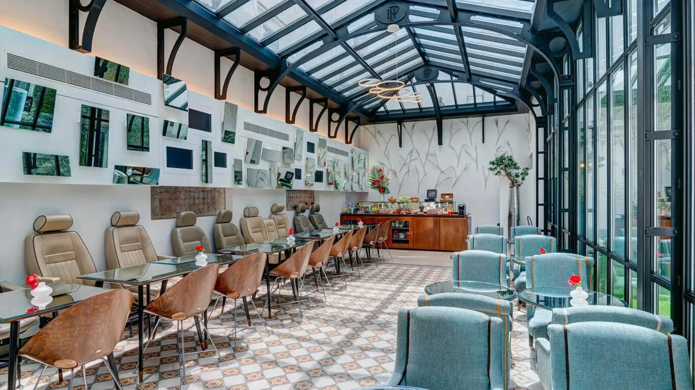 Salle de petit-déjeuner de l’hôtel Joyce 3 étoiles du groupe Astotel à Paris, située sous une verrière avec une décoration originale et un buffet à l’arrière