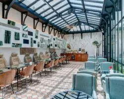 Salle de petit-déjeuner de l’hôtel Joyce 3 étoiles du groupe Astotel à Paris, située sous une verrière avec une décoration originale et un buffet à l’arrière
