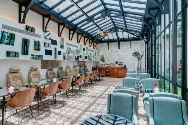 Salle de petit-déjeuner de l’hôtel Joyce 3 étoiles du groupe Astotel à Paris, située sous une verrière avec une décoration originale et un buffet à l’arrière