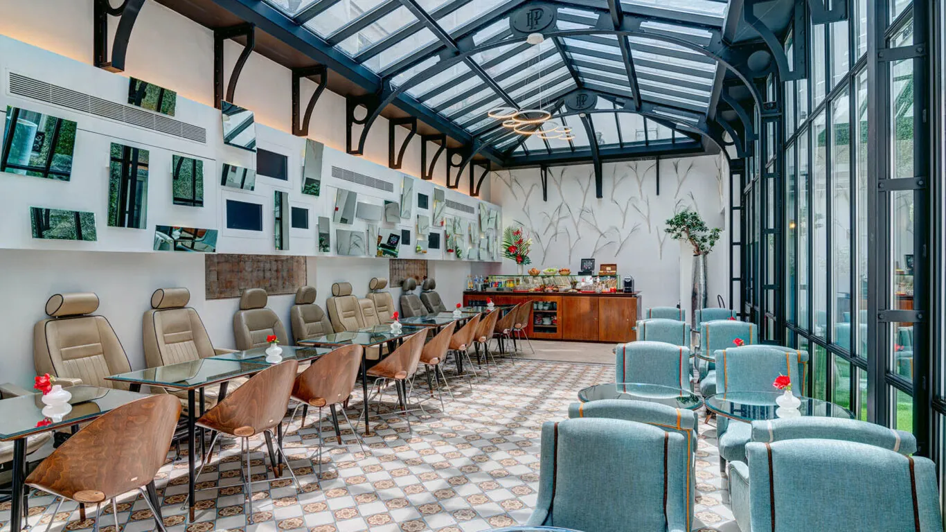 Salle de petit-déjeuner de l’hôtel Joyce 3 étoiles du groupe Astotel à Paris, située sous une verrière avec une décoration originale et un buffet à l’arrière