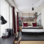 Vue du lit king size d’une Chambre Familiale Privilège avec balcon à l’Hôtel 123 Sébastopol