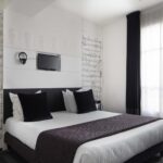 Lit king size d’une Chambre Familiale Privilège avec balcon à l’Hôtel 123 Sébastopol