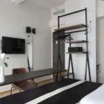 Vue sur l’intérieur et l’écran de télévision d’une Chambre Twin Privilège avec balcon à l’Hôtel 123 Sébastopol