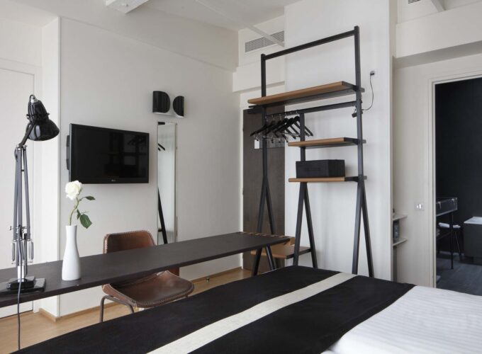 Vue sur l’intérieur et l’écran de télévision d’une Chambre Twin Privilège avec balcon à l’Hôtel 123 Sébastopol