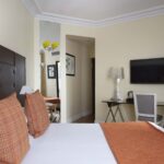 Chambre Double à l’hôtel Le 123 Elysées avec un bureau et une télévision à écran plat