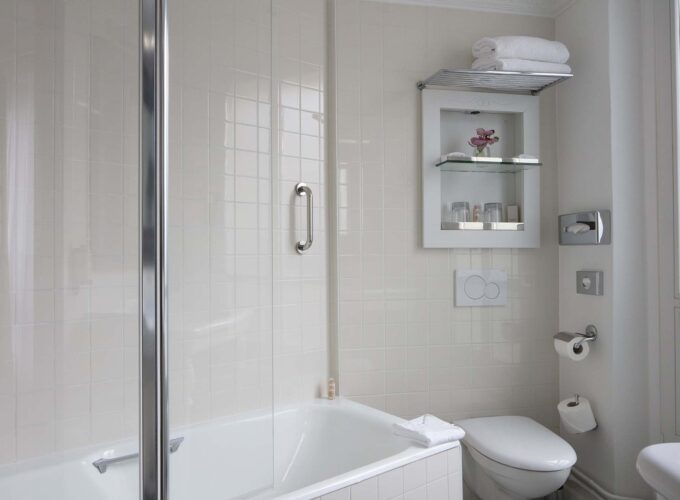 Salle de bain de la Chambre Double à l’hôtel Le 123 Elysées avec des carreaux blancs et des toilettes