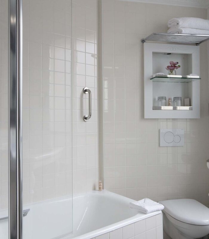Salle de bain de la Chambre Double à l’hôtel Le 123 Elysées avec des carreaux blancs et des toilettes
