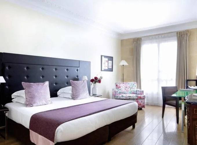 Chambre Double Privilège à l’hôtel Le 123 Elysées avec un grand lit et des oreillers violets