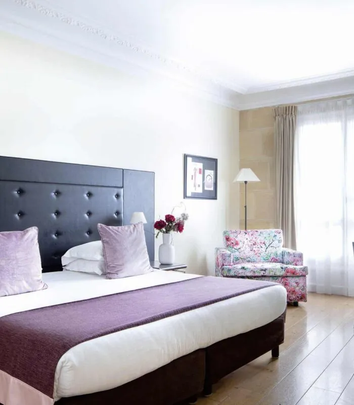 Chambre Double Privilège à l’hôtel Le 123 Elysées avec un grand lit et des oreillers violets