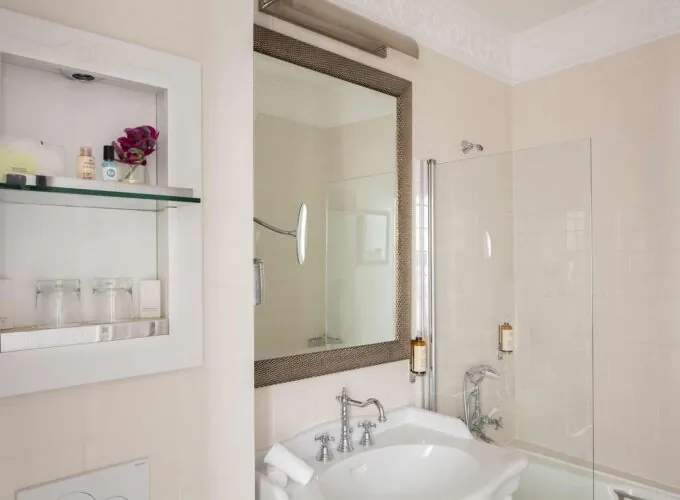 Salle de bain de la Chambre Double Privilège à l’hôtel Le 123 Elysées avec un lavabo, un miroir et une douche en verre
