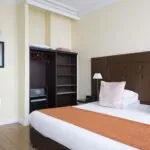 Chambre Double Supérieure à l’hôtel Le 123 Elysées avec un lit et un coffre-fort