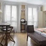 Chambre Familiale à l’hôtel Le 123 Elysées avec deux lits, un bureau et un banc