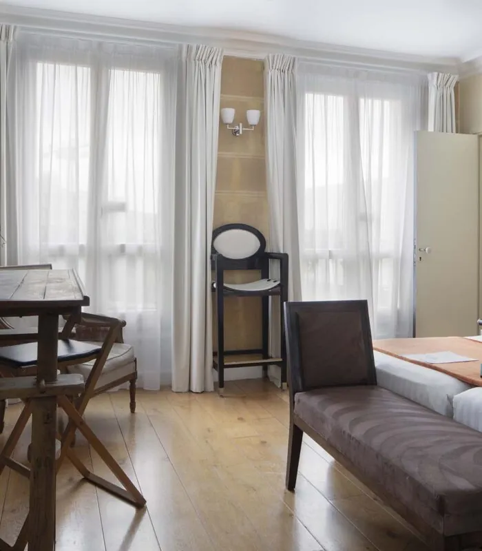 Chambre Familiale à l’hôtel Le 123 Elysées avec deux lits, un bureau et un banc