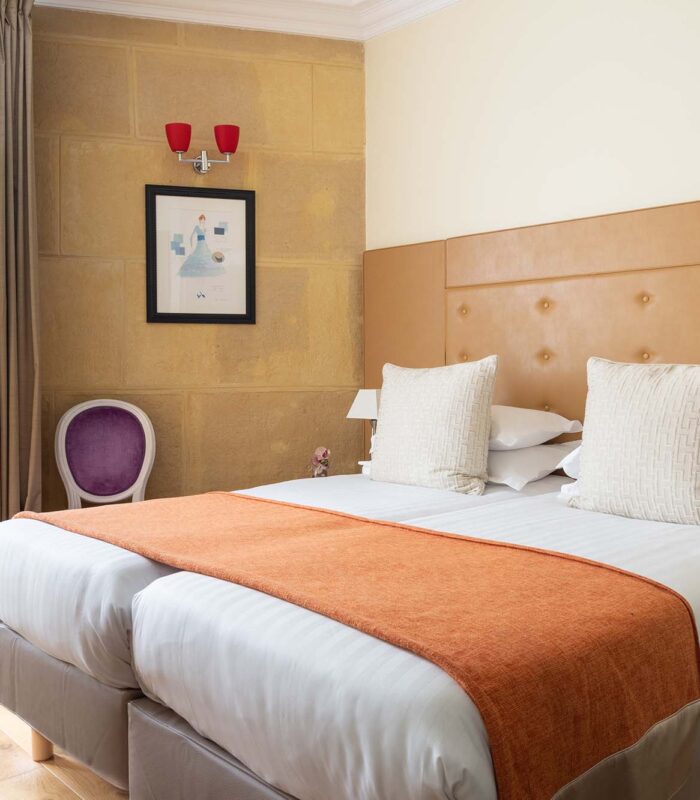 Chambre Familiale à l’hôtel Le 123 Elysées avec deux lits et une chaise violette