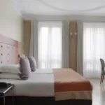 Chambre pour personnes à mobilité réduite à l’hôtel Le 123 Elysées avec deux lits et un bureau