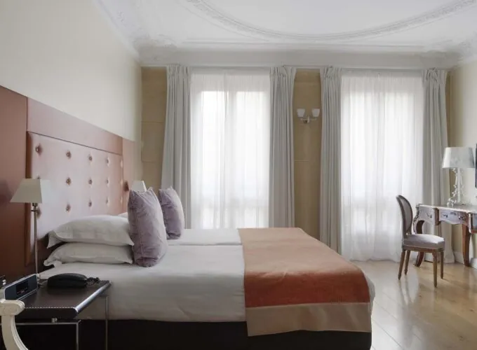 Chambre pour personnes à mobilité réduite à l’hôtel Le 123 Elysées avec deux lits et un bureau