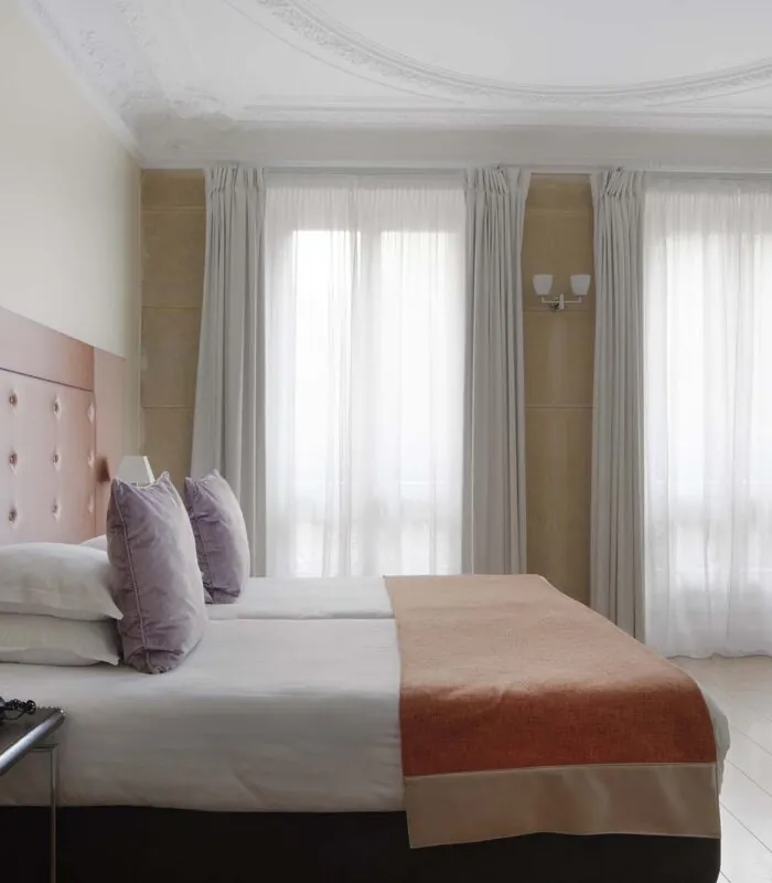 Chambre pour personnes à mobilité réduite à l’hôtel Le 123 Elysées avec deux lits et un bureau