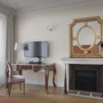 Chambre pour personnes à mobilité réduite à l’hôtel Le 123 Elysées avec une cheminée, un bureau et une télévision à écran plat