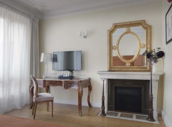 Chambre pour personnes à mobilité réduite à l’hôtel Le 123 Elysées avec une cheminée, un bureau et une télévision à écran plat