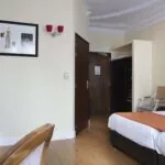 Chambre pour personnes à mobilité réduite à l’hôtel Le 123 Elysées avec un tableau au-dessus du lit