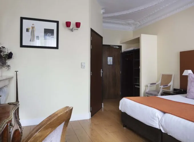 Chambre pour personnes à mobilité réduite à l’hôtel Le 123 Elysées avec un tableau au-dessus du lit