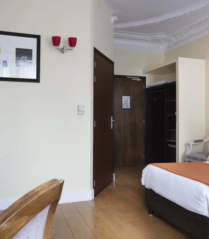 Chambre pour personnes à mobilité réduite à l’hôtel Le 123 Elysées avec un tableau au-dessus du lit
