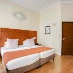 Chambre pour personnes à mobilité réduite à l’hôtel Le 123 Elysées avec deux lits et une porte