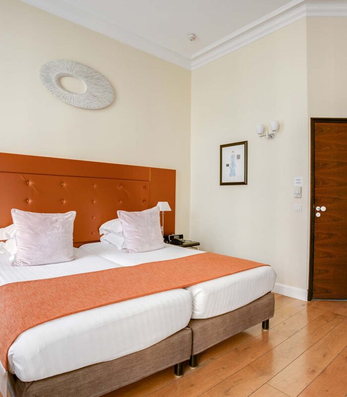 Chambre pour personnes à mobilité réduite à l’hôtel Le 123 Elysées avec deux lits et une porte