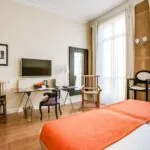 Chambre pour personnes à mobilité réduite à l’hôtel Le 123 Elysées avec un lit, un bureau et une télévision