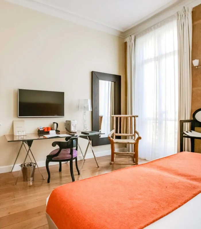Chambre pour personnes à mobilité réduite à l’hôtel Le 123 Elysées avec un lit, un bureau et une télévision