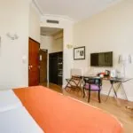 Chambre pour personnes à mobilité réduite à l’hôtel Le 123 Elysées avec un lit, un bureau et une télévision