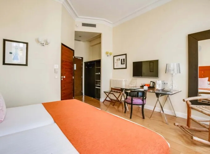 Chambre pour personnes à mobilité réduite à l’hôtel Le 123 Elysées avec un lit, un bureau et une télévision