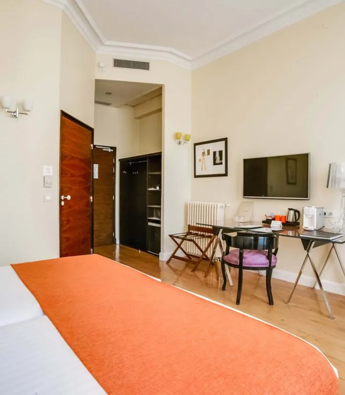 Chambre pour personnes à mobilité réduite à l’hôtel Le 123 Elysées avec un lit, un bureau et une télévision