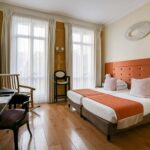 Chambre pour personnes à mobilité réduite à l’hôtel Le 123 Elysées avec deux lits, un bureau et une chaise