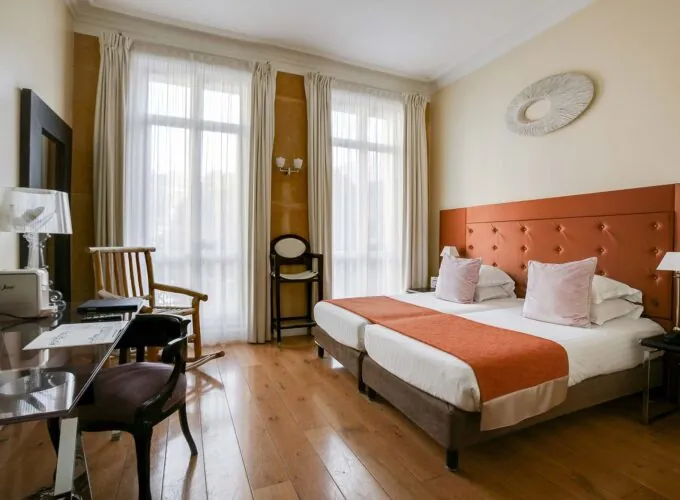 Chambre pour personnes à mobilité réduite à l’hôtel Le 123 Elysées avec deux lits, un bureau et une chaise