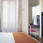 Chambre Single à l’hôtel Le 123 Elysées avec un lit, un bureau et un coffre-fort