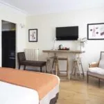 Chambre Twin Supérieure à l’hôtel Le 123 Elysées avec un lit, une chaise et une télévision à écran plat