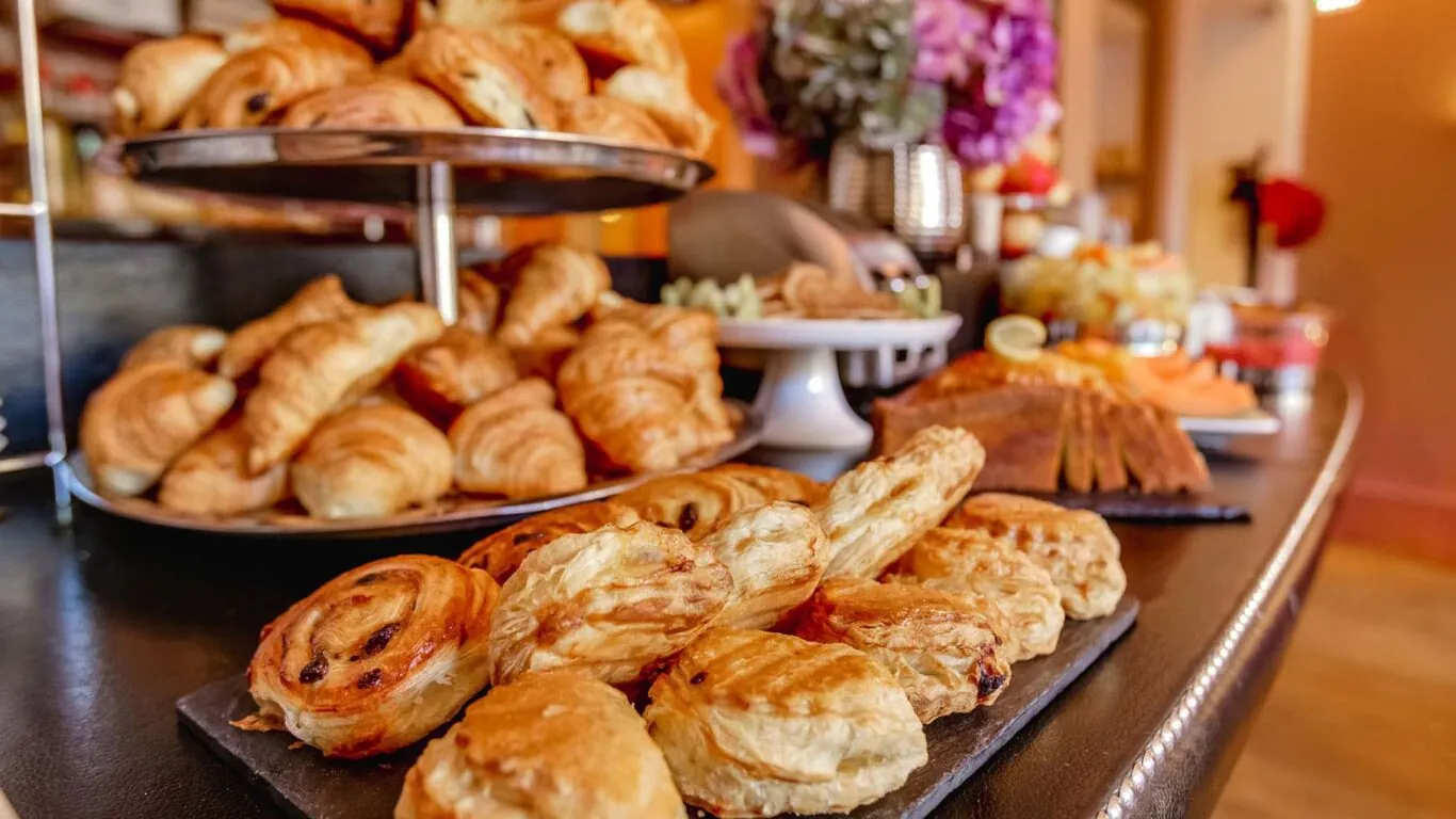 페이스트리, 신선한 빵, 치즈, 샤퀴테리, 따뜻한 음료와 차가운 음료, 요거트, 과일, 시리얼이 포함된 맛있는 뷔페식 아침식사로 하루를 시작하세요...