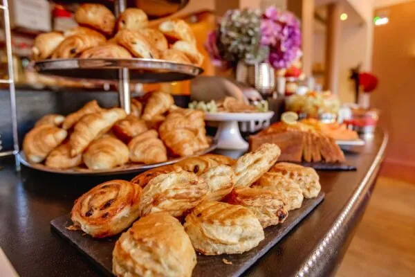 페이스트리, 신선한 빵, 치즈, 샤퀴테리, 따뜻한 음료와 차가운 음료, 요거트, 과일, 시리얼이 포함된 맛있는 뷔페식 아침식사로 하루를 시작하세요...